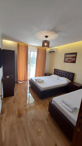 2 łóżka w pokoju z drewnianą podłogą w obiekcie Rinia Apartments w Ulcinju