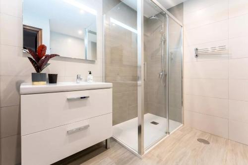 a white bathroom with a shower and a sink at Casa capitán in Fuengirola