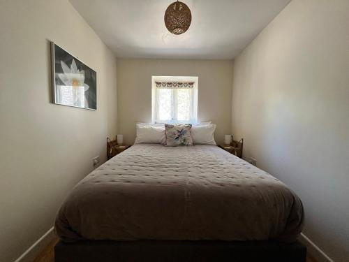um quarto com uma cama grande e uma janela em Abercrymlyn barn em Llanwrda