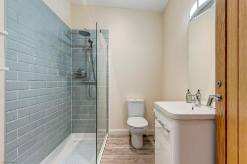 La salle de bains est pourvue d'une douche, de toilettes et d'un lavabo. dans l'établissement Highlander Barn, à Minster Lovell