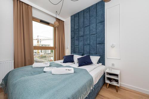 ein Schlafzimmer mit einem großen Bett und einem Fenster in der Unterkunft Porto - BillBerry Apartments in Danzig