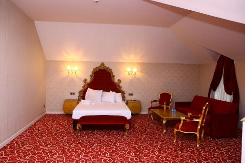 a hotel room with a bed and a couch at Deluxe Hotel Ganja in Ganja