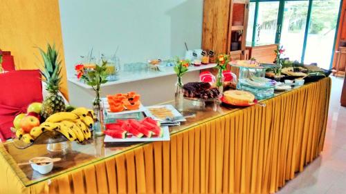 un buffet con frutas y verduras en un mostrador en Castelo Piazzale - Campos do Jordao, en Campos do Jordão