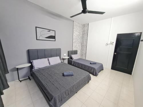 1 dormitorio con 2 camas y ventilador de techo en Air-home M1 Simpang near Aulong Econsave, 4BR, 10pax, Netflix, en Simpang