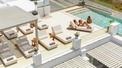 uma vista aérea de uma villa com piscina e 2 pessoas sentadas em cadeiras em Parian Lithos Residence em Naousa