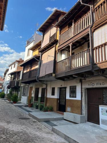 an old building with wooden balconies on a street at CASA 1860 CANDELEDA in Candeleda