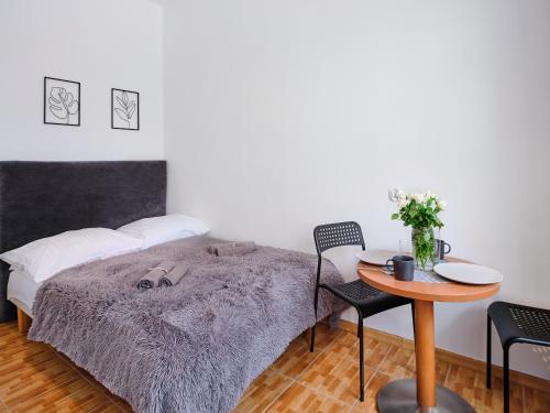 a bedroom with a bed and a table and a table and chairs at LOFT ROOMS ŁEBA in Łeba