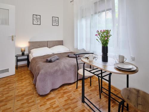 a bedroom with a bed and a table with flowers on it at LOFT ROOMS ŁEBA in Łeba