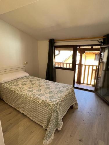 1 dormitorio con cama y ventana grande en CASA 1860 CANDELEDA, en Candeleda