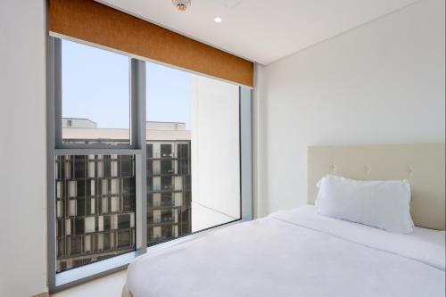a bedroom with a white bed and a large window at Prime 3BR Suite in Bluewaters - Full Ain Dubai View - Livbnb in Dubai
