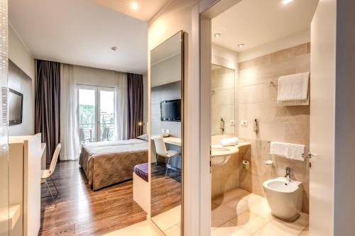 a hotel room with a bed and a bathroom at Hotel Isola Sacra Rome Airport in Fiumicino