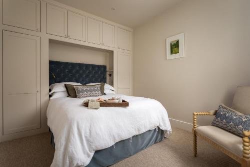 a bedroom with a bed with a blue headboard and a chair at No 5 Winchester in Winchester