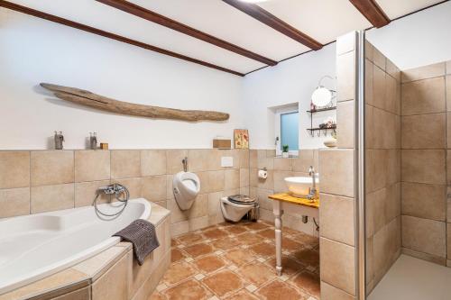 ein Badezimmer mit einer Badewanne, einem WC und einem Waschbecken in der Unterkunft Augensteins Burgzimmer in Seelbach