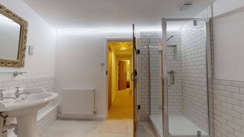 uma casa de banho branca com um lavatório e um chuveiro em Bushnells Cottage em Oxford