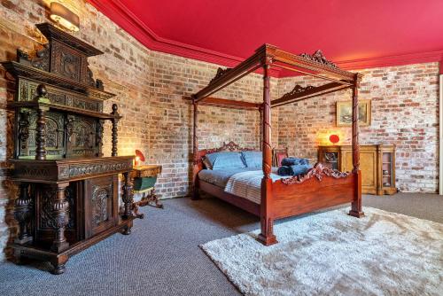 唐克斯特的住宿－Finest Retreats - Hickleton Hall Estate，一间卧室设有天蓬床和砖墙