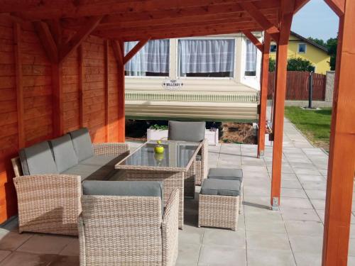 a patio with wicker furniture and a table and chairs at Mobilní dům u Mikeše Trhové Sviny - Rejta in Trhové Sviny