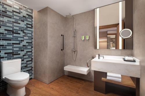 a bathroom with a toilet and a sink and a mirror at Fairfield by Marriott Baiyin Downtown in Baiyin