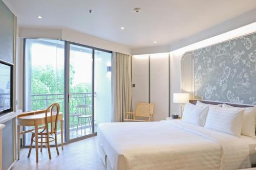 a hotel room with a bed and a balcony at The Quarter Chaophraya by UHG in Bangkok