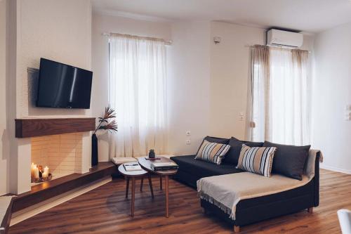 a living room with a couch and a tv at The Repose Aesthetic Apt. R1 in Heraklio Town
