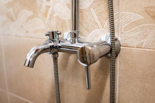 a shower with a shower head in a bathroom at Abstract Apartment in Varna City