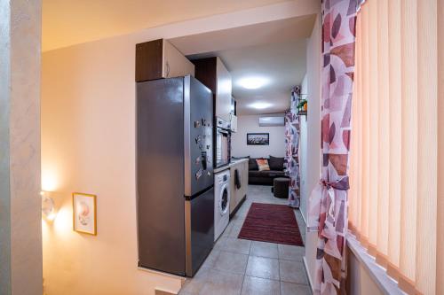 a hallway with a stainless steel refrigerator in a kitchen at Abstract Apartment in Varna City