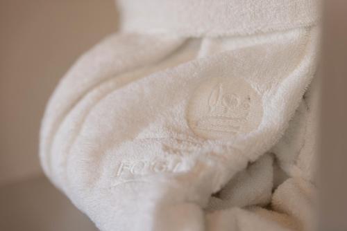 a hand holding a towel with a button on it at TENUTA FOGLIANI Resort & Natural Spa in Visciano