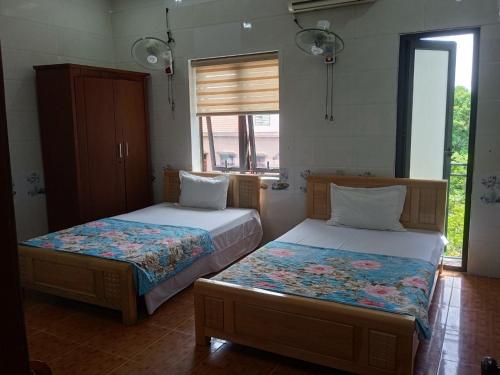 a bedroom with two beds and a window at Hotel Thanh Bình 2 in Ha Tinh