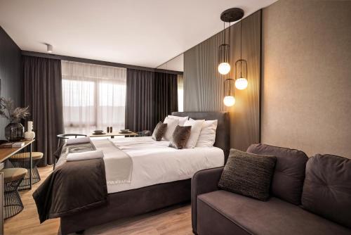 a bedroom with a large bed and a couch at Boutique Residence Gdańsk in Gdańsk