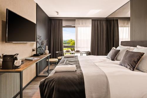 a hotel room with a bed and a desk with a television at Royal Apartments - Boutique Residence Gdańsk in Gdańsk