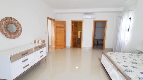 a bedroom with a bed and a dresser and a mirror at Amar'e Aparthotel & Spa in Las Terrenas
