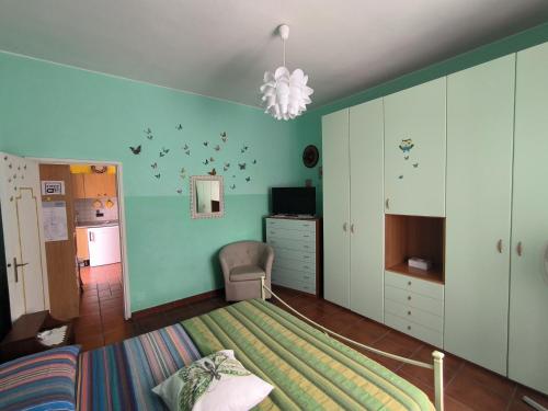 a bedroom with a bed with a green wall at Primula by Villa Very in Marina di Campo