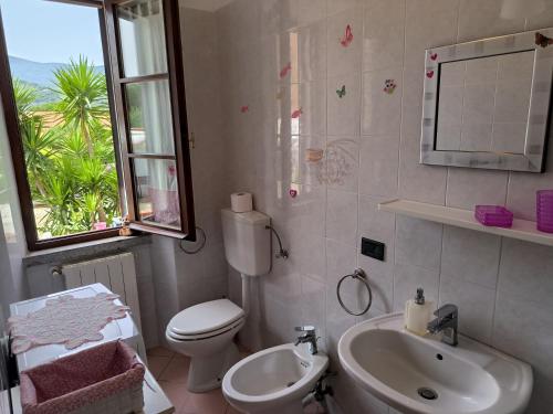 a bathroom with a sink and a toilet and a window at Primula by Villa Very in Marina di Campo