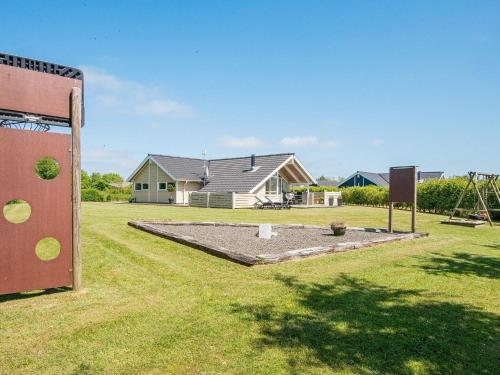 a playground in a yard with a house at 8 person holiday home in Hemmet in Falen