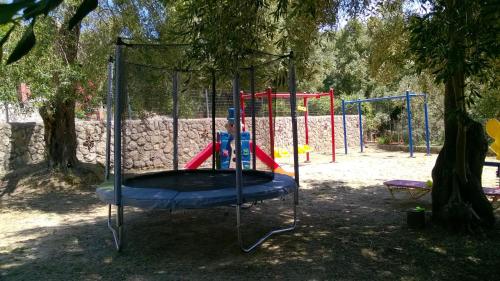 un columpio en un parque con un árbol en Bozikis Apartments & Studios, en Paleokastritsa