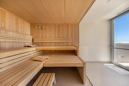 a sauna with wooden benches and a window at El Somni Ibiza Dream Hotel by Grupotel in Sant Joan de Labritja