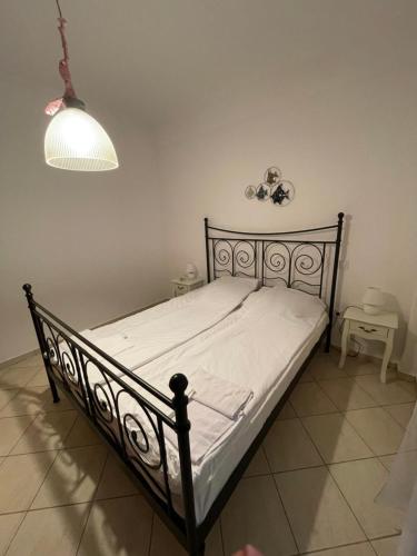 a bedroom with a bed with a white bedspread and a lamp at Aurora Apartment in Afitos