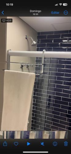 a bathroom with a towel hanging from a shower at Unique Gonzaga Santos -Perto de tudo, 5min da praia in Santos