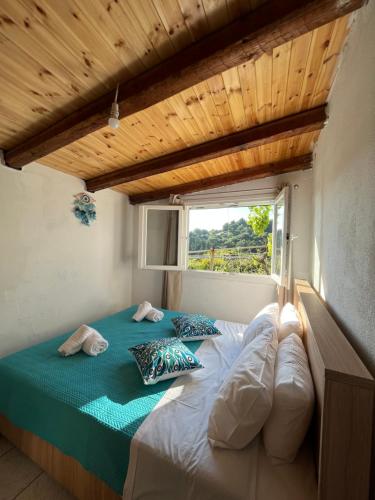 a bedroom with a large bed with a window at Rodovani Cottage in Antípaxos