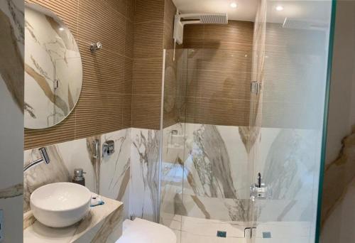 a bathroom with a shower and a toilet and a sink at Flat Asa Norte CLN 311 by CentoEdez in Brasilia
