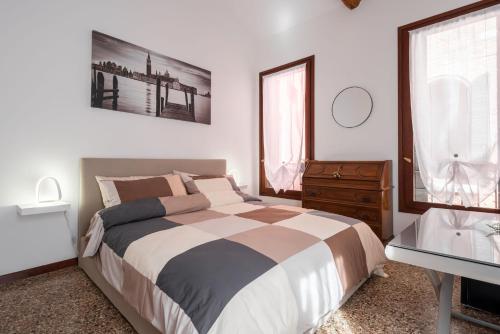 a bedroom with a bed and a dresser and a window at Suite Ravà - San Marco with pool in Venice