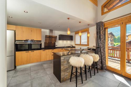 une cuisine avec un bar avec des tabourets en fourrure dans l'établissement Colibri Penthouse, à Morzine