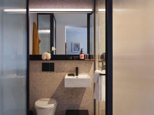 a bathroom with a sink and a toilet and a mirror at Penny Williamsburg in Brooklyn