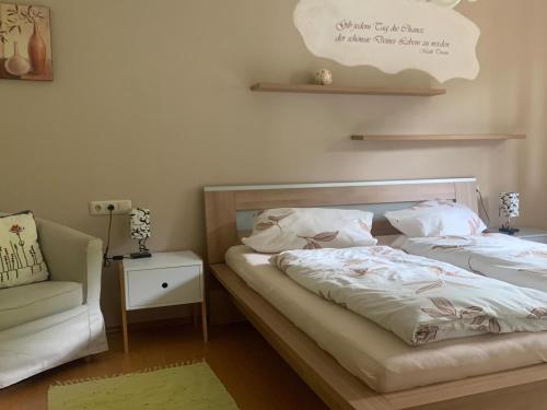 a bedroom with two beds and a couch and a chair at Ferienwohnungen Monika Kloiber in Ruhpolding