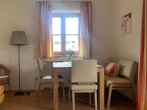 a dining room with a table and chairs and a window at Ferienwohnungen Monika Kloiber in Ruhpolding