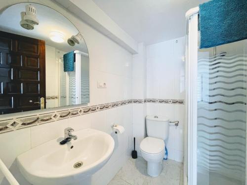 Un baño blanco con lavabo e inodoro. en Calamedina 4, en Salobreña