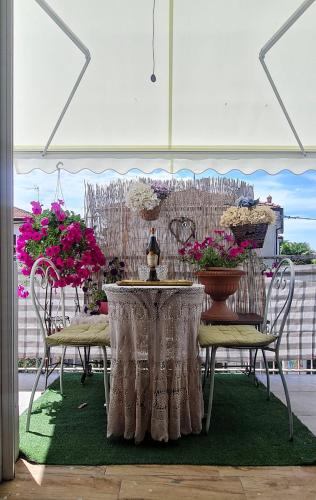 a table and chairs with flowers on a patio at La casina dell'artista in Ravenna