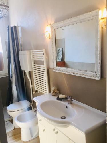 a bathroom with a sink and a toilet and a mirror at La casina dell'artista in Ravenna