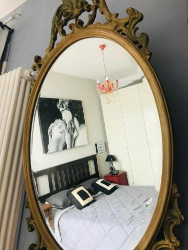 a mirror in a bedroom with a bed in it at La casina dell'artista in Ravenna