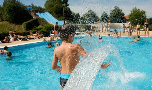 un jeune garçon jouant dans une piscine dans l'établissement Camping Onlycamp le Champ d'été, à Reyssouze