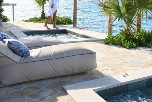 a person is standing on a patio near a swimming pool at Paradisso Beach Villas in Zakynthos Town